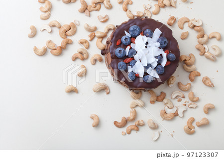 Vegan chocolate beet cake with blackberries, decorated with nuts and seeds coconut top view on white 97123307