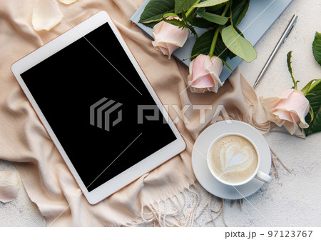 Top view a cup of coffee latte art heart shape with a pink rose and tablet Top view a cup of coffee latte art heart shape with a pink rose and tablet 97123767