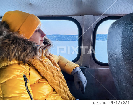 Woman in yellow jacket sitting in the khivus. Ice travel in winter holidays Woman in yellow jacket sitting in the khivus. Ice travel in winter holidays 97125021