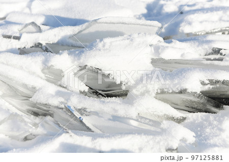 Pieces of ice lying on the ideal smooth ice of baikal with ice hummocks in the horizon 97125881