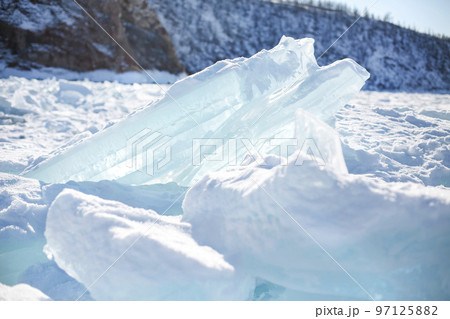 Pieces of ice lying on the ideal smooth ice of baikal with ice hummocks in the horizon Pieces of ice lying on the ideal smooth ice of baikal with ice hummocks in the horizon 97125882