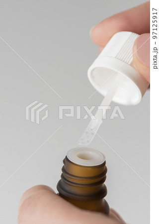 Cure for warts. Bottle with medicine for the treatment of warts in the hands of a woman close-up. Treatment and prevention of warts Cure for warts. Bottle with medicine for the treatment of warts in the hands of a woman close-up. Treatment and prevention of warts 97125917