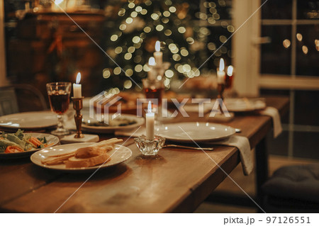 Christmas table is served with a duck, decorated with bright tinsel and candles 97126551