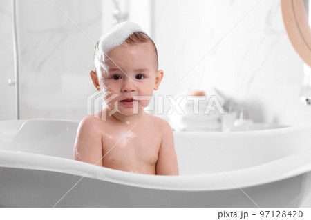 Cute little baby in bathtub at home 97128420