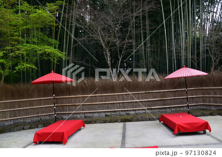 日本の京都 茶屋と竹垣と周辺の竹藪 床几台と呼ばれる赤い布を被せた縁台と赤い傘 日本の京都 茶屋と竹垣と周辺の竹藪 床几台と呼ばれる赤い布を被せた縁台と赤い傘 97130824
