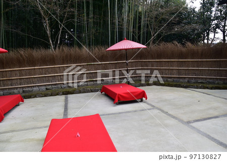 日本の京都 茶屋と竹垣と周辺の竹藪 床几台と呼ばれる赤い布を被せた縁台と赤い傘 日本の京都 茶屋と竹垣と周辺の竹藪 床几台と呼ばれる赤い布を被せた縁台と赤い傘 97130827
