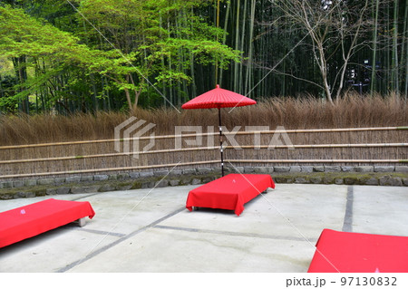 日本の京都　茶屋と竹垣と周辺の竹藪　床几台と呼ばれる赤い布を被せた縁台と赤い傘 97130832