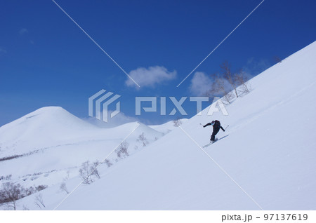 北海道バックカントリー　大斜面を滑るスキーヤー 97137619