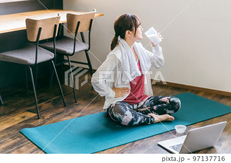 家でヨガをしながらプロテインを飲むアジア人女性 家でヨガをしながらプロテインを飲むアジア人女性 97137716