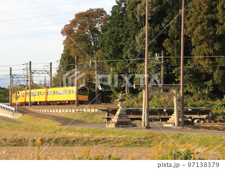 神社の参道を横切って走行する三岐鉄道北勢線の電車 97138379