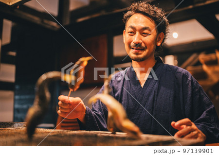鮎を塩焼きする居酒屋の店主 97139901