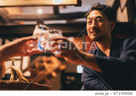 囲炉裏でお酒を飲む髭の男性 97140006