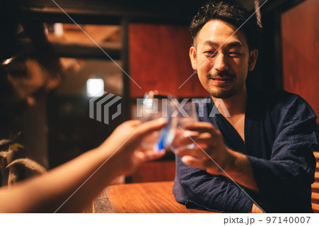 囲炉裏でお酒を飲む髭の男性 97140007