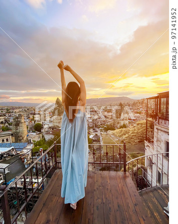 Young woman in dress on the roof with amazing view of Cappadocia in Turkey 97141952