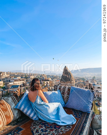 Young woman in dress on the roof with amazing view of Cappadocia in Turkey 97141969
