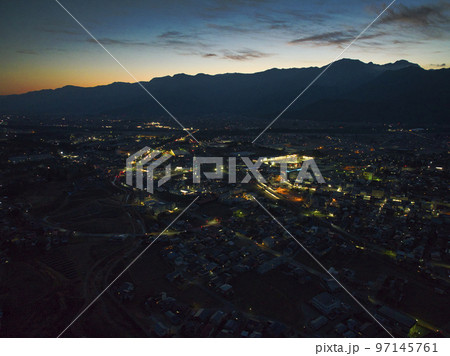 夕焼けに浮かぶ北アルプスの美しいシルエットと大町市の夜景　長野県大町市（ドローンによる空撮） 97145761