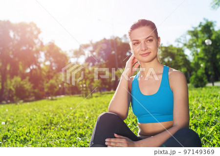 Beautiful smiling girl in sportswear relax in park Beautiful smiling girl in sportswear relax in park 97149369