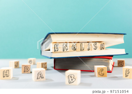 English Language Day. On the table there are books and wooden cubes with the inscription english. Turquoise background. The concept of learning foreign languages English Language Day. On the table there are books and wooden cubes with the inscription english. Turquoise background. The concept of learning foreign languages 97151054