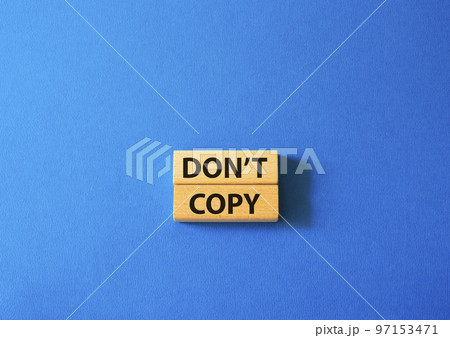 Don't copy symbol. Wooden blocks with words Don't copy. Beautiful blue background. Business and Don't copy concept. Copy space. 97153471