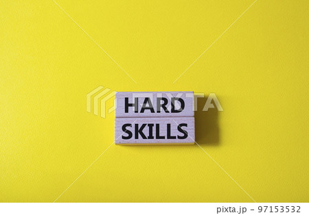 Hard skills symbol. Wooden blocks with words Hard skills. Beautiful yellow background. Businessman hand. Business and Hard skills concept. Copy space 97153532