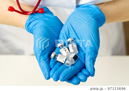 doctor holds in hands small ampoules of Covid-19 vaccine doctor holds in hands small ampoules of Covid-19 vaccine 97153696