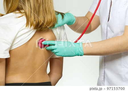 Little girl at the family doctor. lung area examined with stethoscope. Pediatrician checks the health, listens to the child with a Stethoscope. 97153700