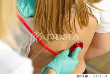 Little girl at the family doctor. lung area examined with stethoscope. Pediatrician checks the health, listens to the child with a Stethoscope. 97153701