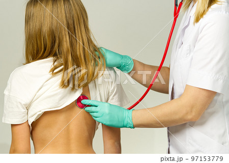 Little girl at the family doctor. lung area examined with stethoscope. Pediatrician checks the health, listens to the child with a Stethoscope. 97153779