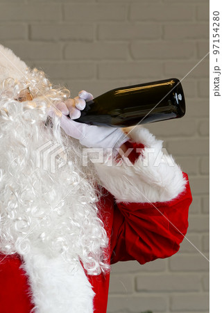 Santa claus drinking sparkling wine from bottle. drunk santa claus concept Santa claus drinking sparkling wine from bottle. drunk santa claus concept 97154280