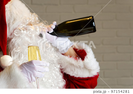 Santa claus drinking sparkling wine from bottle. drunk santa claus concept Santa claus drinking sparkling wine from bottle. drunk santa claus concept 97154281