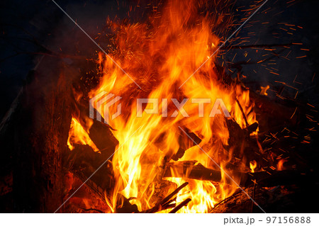 Colorful flame and sparks from a bonfire on a dark background Colorful flame and sparks from a bonfire on a dark background 97156888