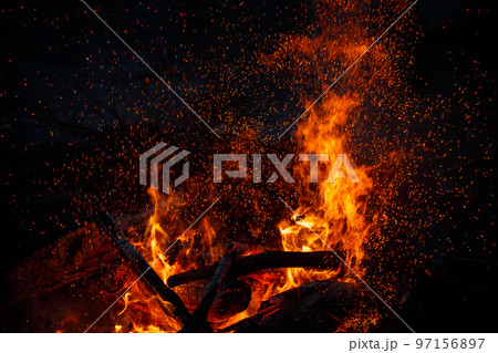 Campfire flame with sparks flying up at night Campfire flame with sparks flying up at night 97156897