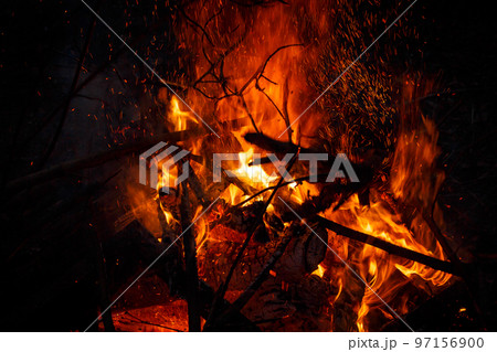 Campfire flame with sparks flying up at night Campfire flame with sparks flying up at night 97156900