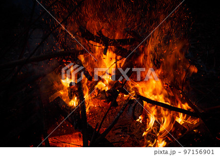 Campfire flame with sparks flying up at night Campfire flame with sparks flying up at night 97156901