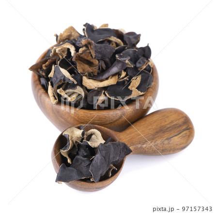 Dry black fungus in wooden bowl and spoon, isolated on white background. Chinese black mushroom or tree black muer mushroom. Auricularia polytricha. 97157343
