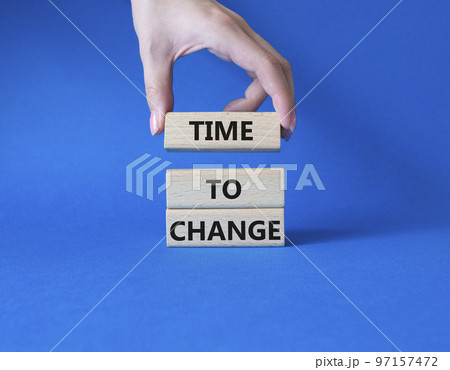Time to change symbol. Concept word Time to change on wooden blocks. Businessman hand. Beautiful blue background. Business and Time to change concept. Copy space 97157472