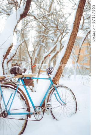 Old antique bike covered with snow in winter time Old antique bike covered with snow in winter time 97157955