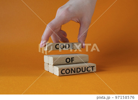 Code of conduct symbol. Wooden blocks with words Code of conduct. Beautiful orange background. Businessman hand. Business and Code of conduct concept. Copy space. Code of conduct symbol. Wooden blocks with words Code of conduct. Beautiful orange background. Businessman hand. Business and Code of conduct concept. Copy space. 97158576