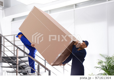 Professional workers carrying refrigerator on stairs indoors Professional workers carrying refrigerator on stairs indoors 97161364
