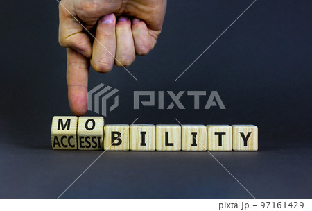 Mobility and accessibility symbol. Businessman turns wooden cubes and changes the word accessibility to mobility. Business and dream and do bigger concept. Beautiful grey background, copy space. Mobility and accessibility symbol. Businessman turns wooden cubes and changes the word accessibility to mobility. Business and dream and do bigger concept. Beautiful grey background, copy space. 97161429