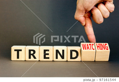 Trend or trendwatching symbol. Concept words Trend and trendwatching on wooden cubes. Businessman hand. Beautiful grey table grey background. Business trend or trendwatching concept. Copy space. 97161544