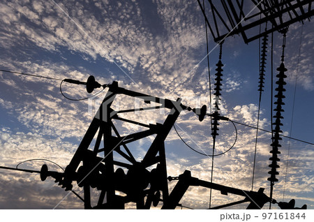 Electricity pylon (high voltage power line), black contour,  against the background of a romantic evening sky 97161844