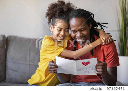 Father's Day. Black Preteen Daughter Giving Handmade Greeting Card And Embracing Dad 97162471