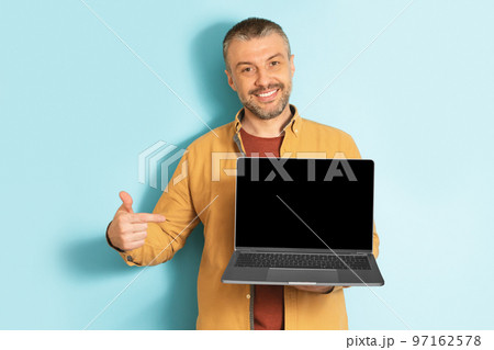 Happy mature caucasian man showing laptop computer empty screen, recommending website, mockup 97162578