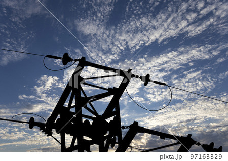Electricity pylon (high voltage power line), black contour,  on the background of the cloudy sky 97163329