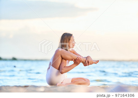 attractive woman practicing yoga by the lake. Downdog downward f 97164306