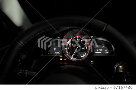 Glowing dashboard showing engine revolutions and speed inside a car Glowing dashboard showing engine revolutions and speed inside a car 97167430