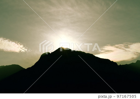 北杜市白州町、甲斐駒ケ岳山頂に沈む夕日と彩雲 97167505