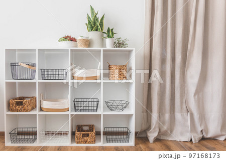 White stylish shelf in scandi style. Storage baskets. Japanese method organizer boxes set. Closet organizing concept. 97168173