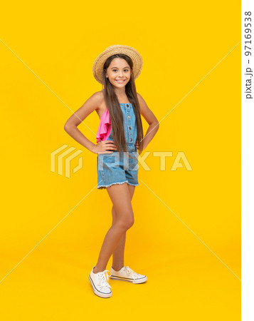 teen girl smile in straw hat standing on yellow background 97169538